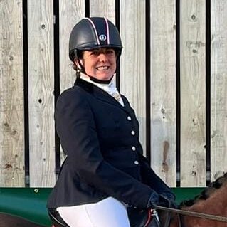 kat williams-jones dressage coach in gloucestershire and riding horse in a riding lesson